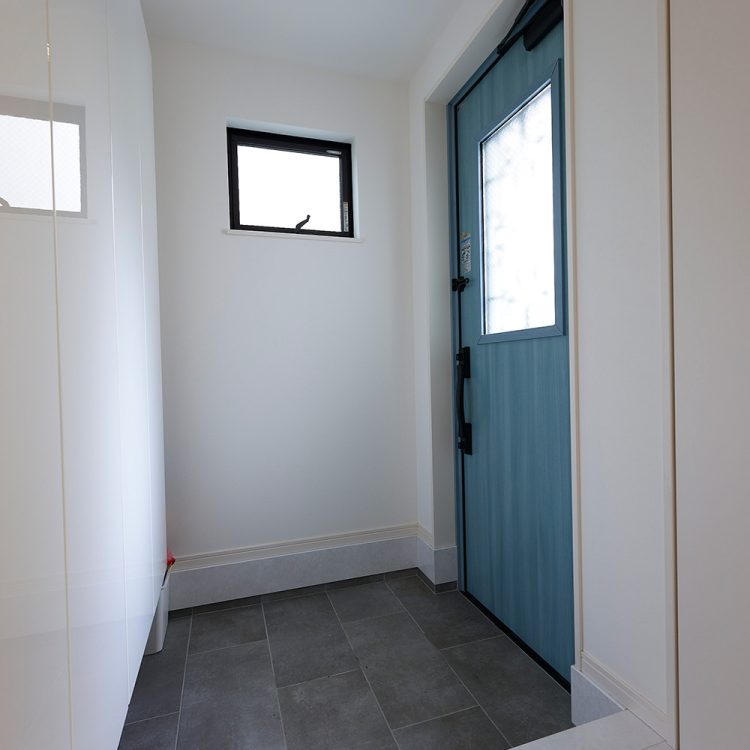 フォーライフ　白を基調とした空間にドアの色がアクセントとなっている玄関