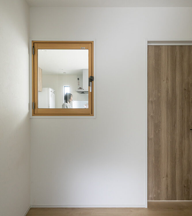 フォーライフ　玄関とキッチンの間に室内窓を設置。玄関ホールに光を導き、帰宅時にお互いを確認できるように。